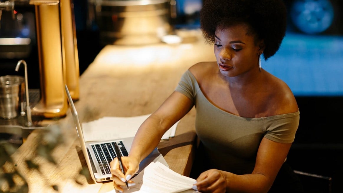 Black-woman-writes-on-notepad-celebrate-Black-authors