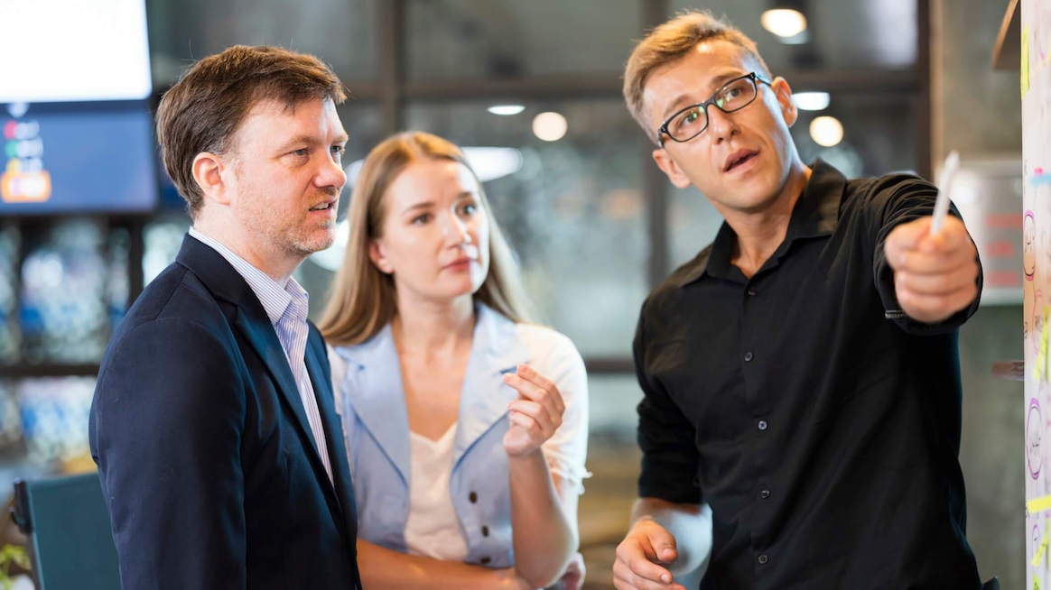 feedback-for-coworkers-colleagues-talking-at-whiteboard