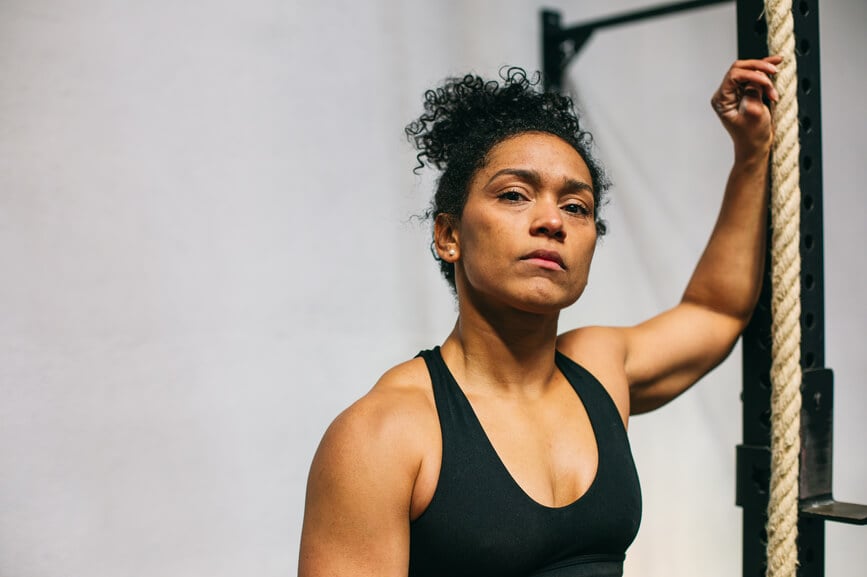 strong-woman-in-tank-top-rests -after-workout-reinventing-yourself